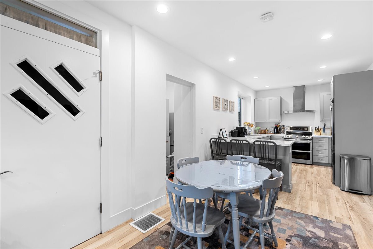 3144 North Spaulding Avenue, Unit 1 Chicago, IL 60618 - Photo 6 of 13 a kitchen with stainless steel appliances granite countertop a dining table chairs refrigerator and cabinets
