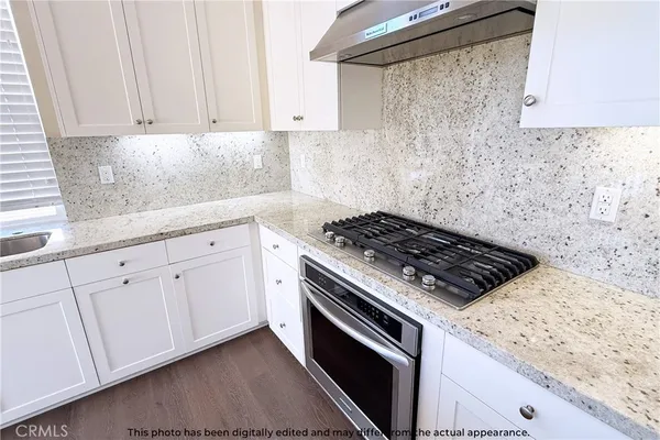 a kitchen with granite countertop white cabinets and white appliances