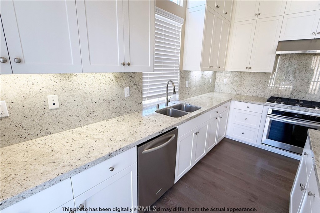 107 Mighty Oak Irvine, CA 92602 - Photo 13 of 22 a kitchen with granite countertop white cabinets and white appliances