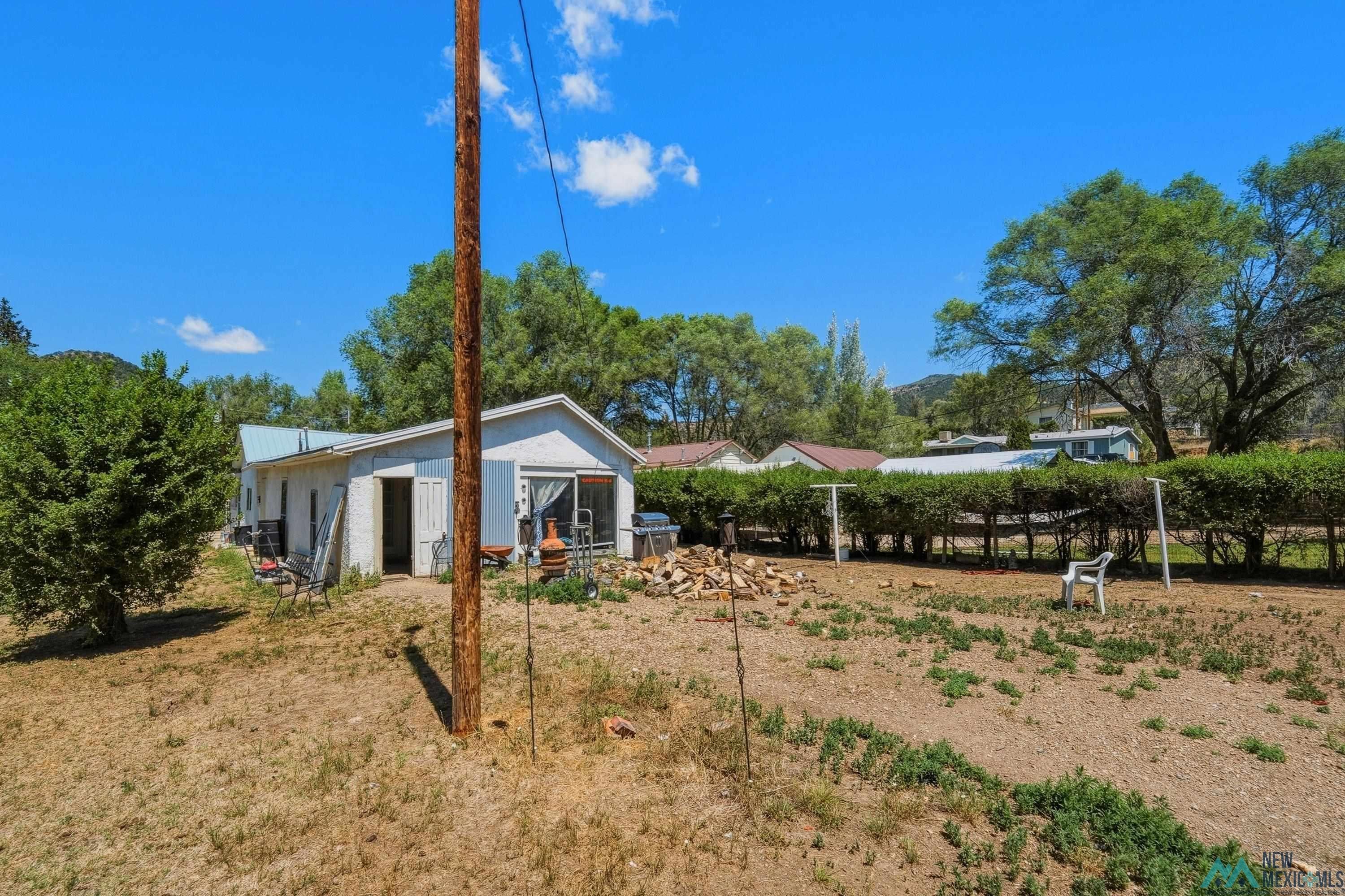 811 North 4th Street Raton, NM 87740 - Photo 21 of 26 Exterior property with a light-colored facade, sliding glass door, and a utility pole
