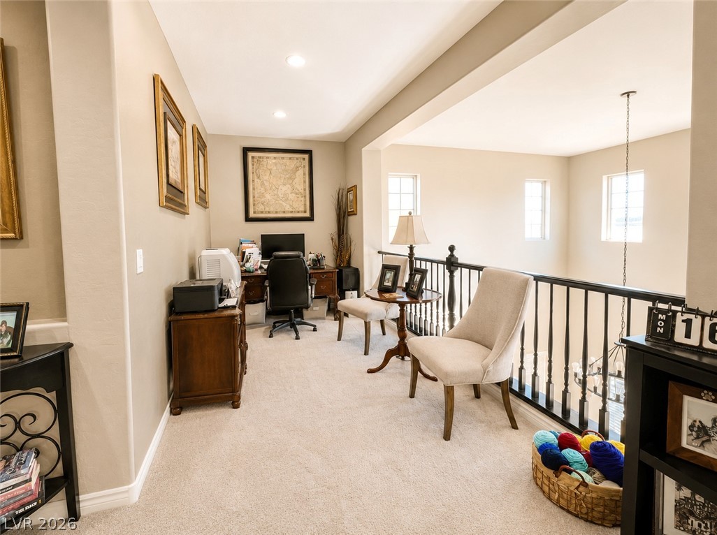 9724 University Ridge Avenue Las Vegas, NV 89149 - Photo 45 of 61 An inviting open-concept loft with soft carpeting and recessed lighting, offering a versatile space for work or relaxation.