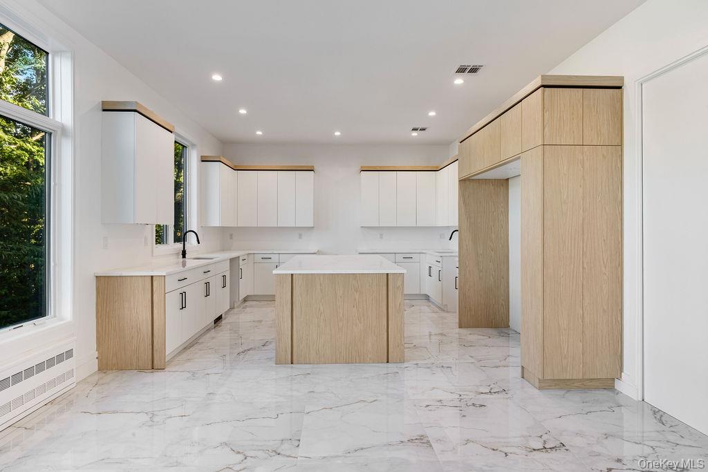 40 Singer Avenue, Unit 201 Spring Valley, NY 10977 - Photo 12 of 50 a large white kitchen with cabinets a sink a window and stainless steel appliances