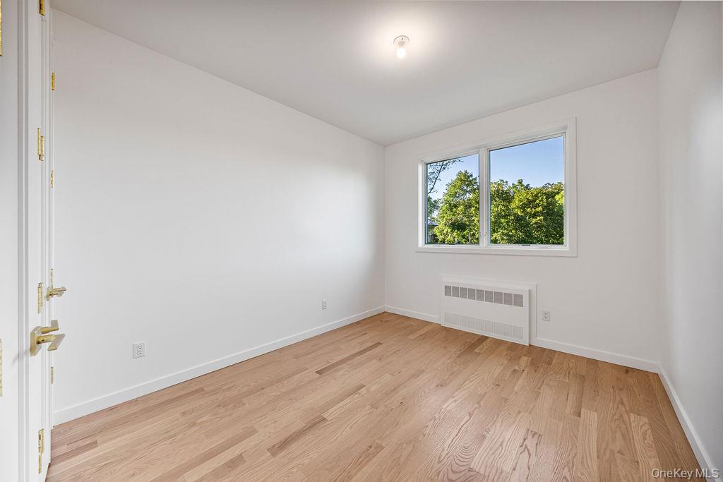 40 Singer Avenue, Unit 201 Spring Valley, NY 10977 - Photo 28 of 50 an empty room with wooden floor and windows