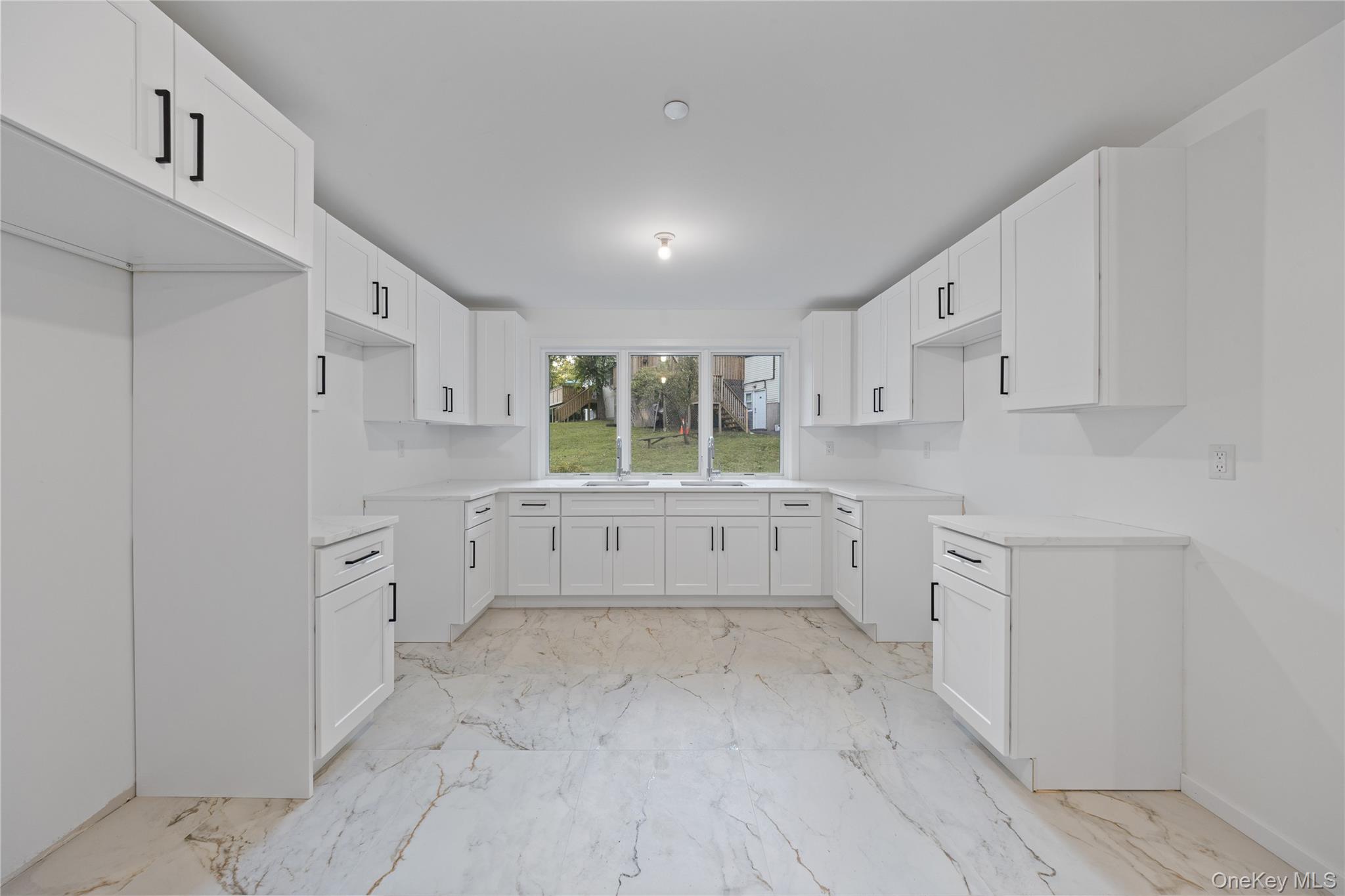 40 Singer Avenue, Unit 201 Spring Valley, NY 10977 - Photo 40 of 50 a kitchen with white cabinets and wooden floors