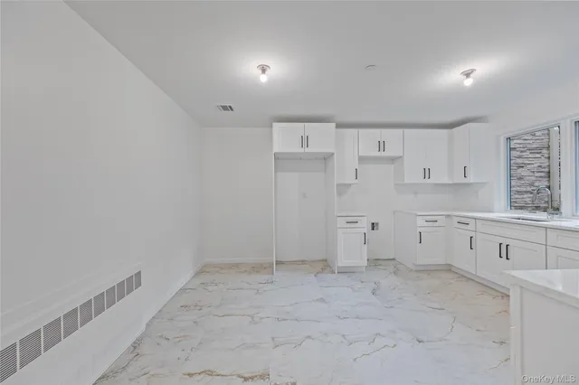 a view of a kitchen with white cabinets