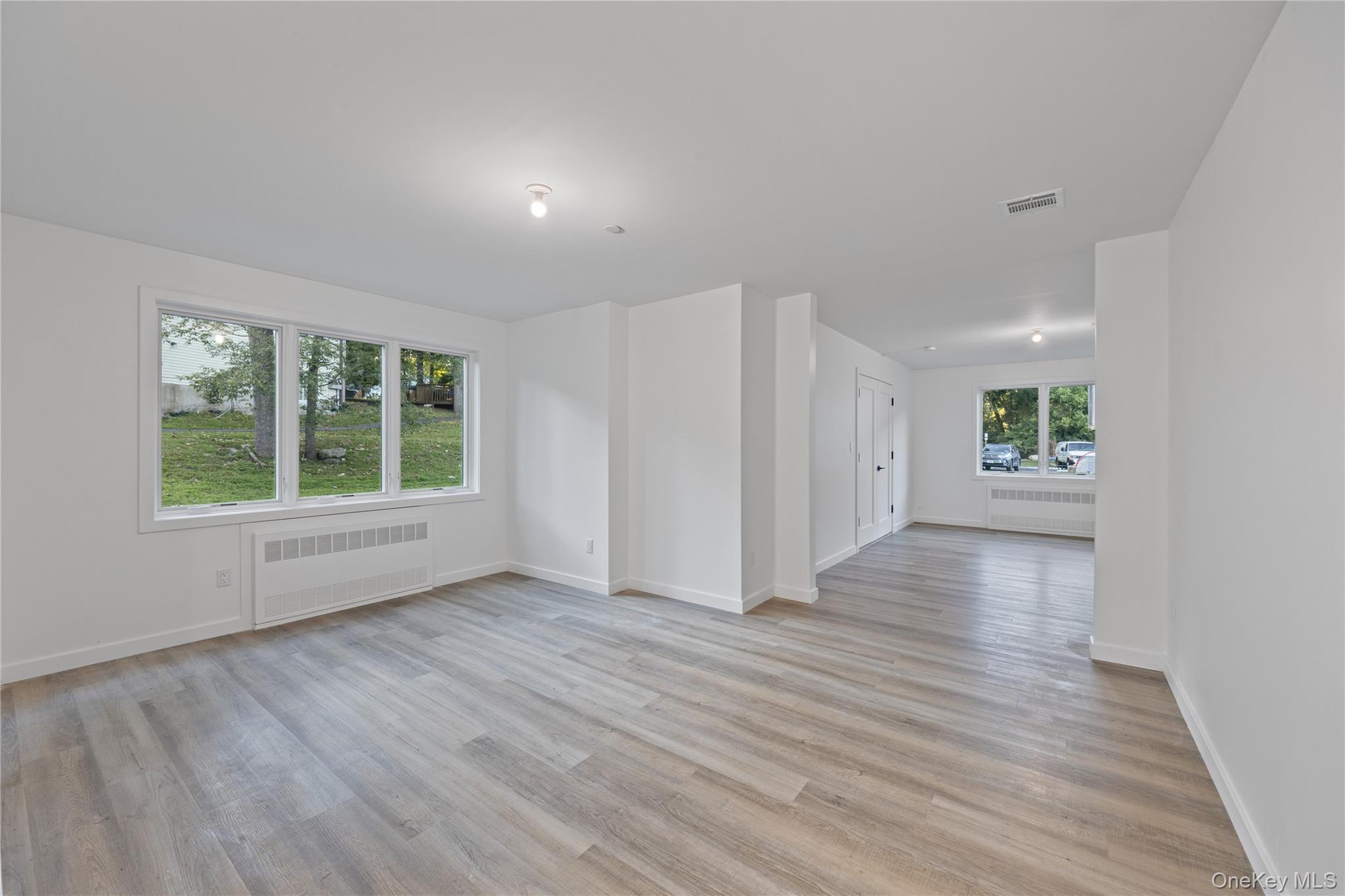 40 Singer Avenue, Unit 201 Spring Valley, NY 10977 - Photo 42 of 50 an empty room with wooden floor and windows