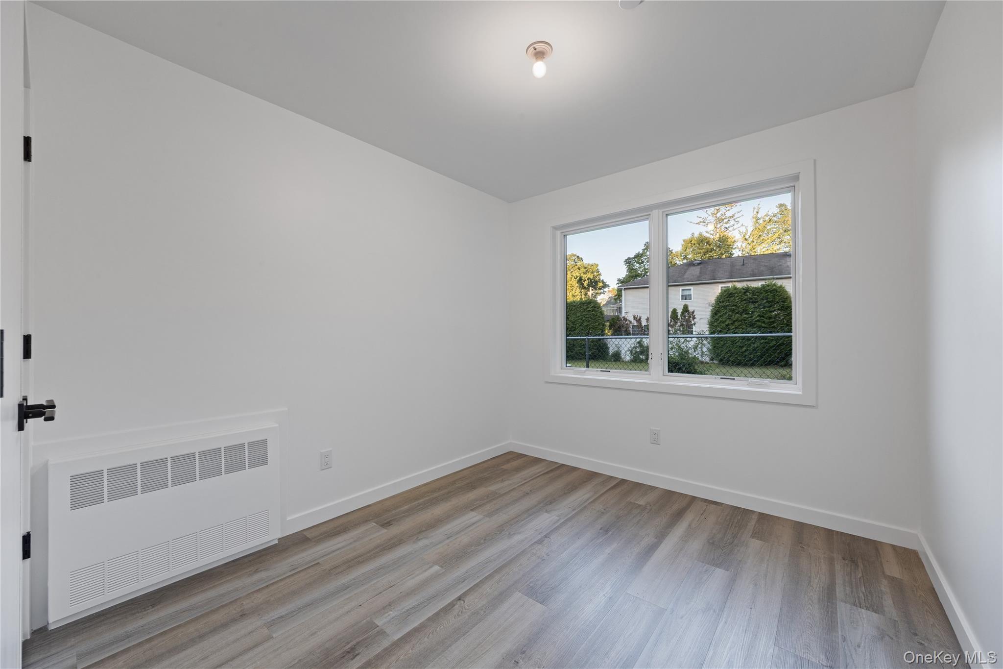 40 Singer Avenue, Unit 201 Spring Valley, NY 10977 - Photo 46 of 50 a view of an empty room with wooden floor and a window