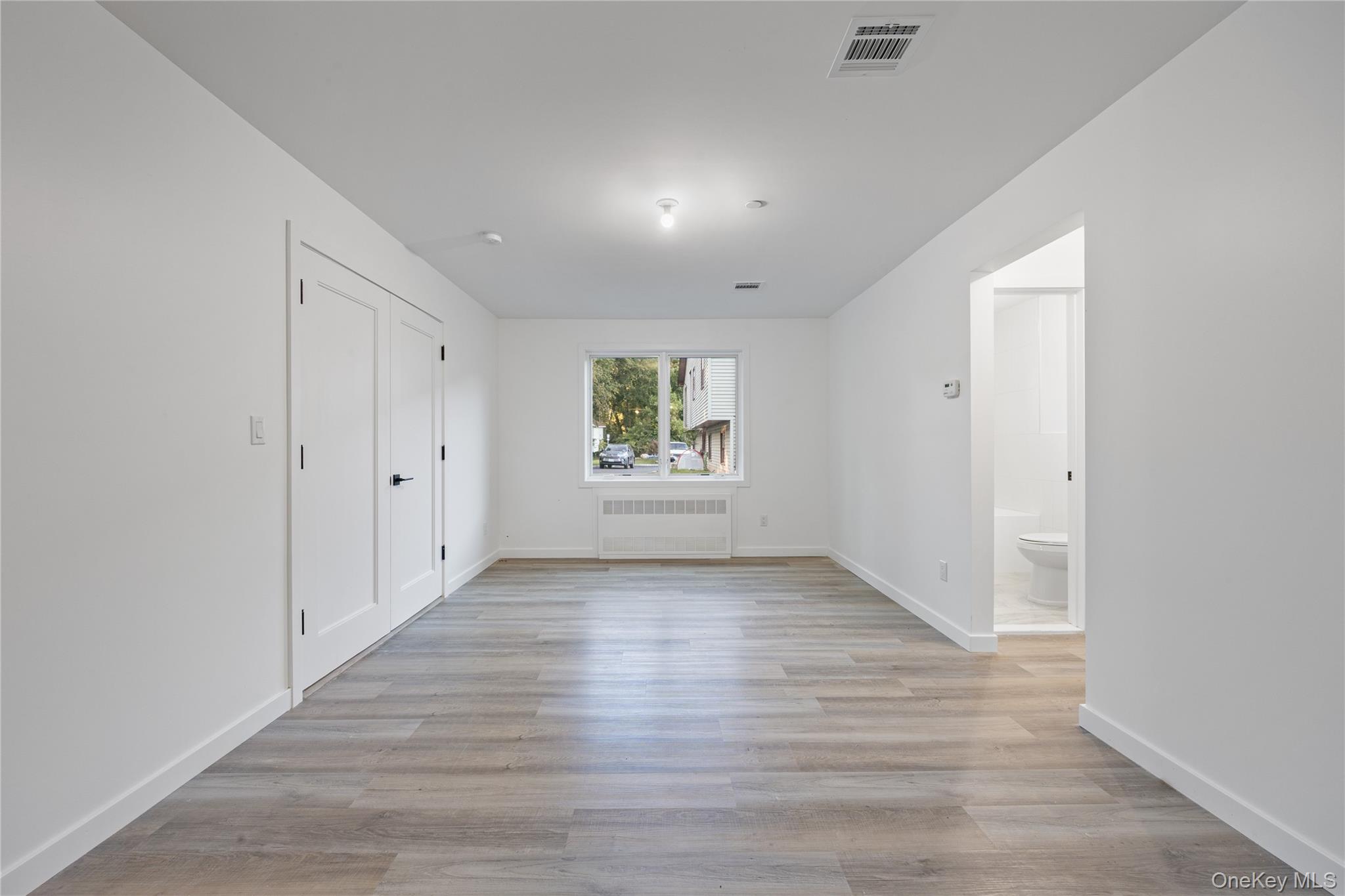 40 Singer Avenue, Unit 201 Spring Valley, NY 10977 - Photo 49 of 50 an empty room with wooden floor and windows