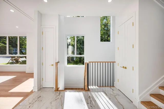 a view of a hallway with wooden floor and a window
