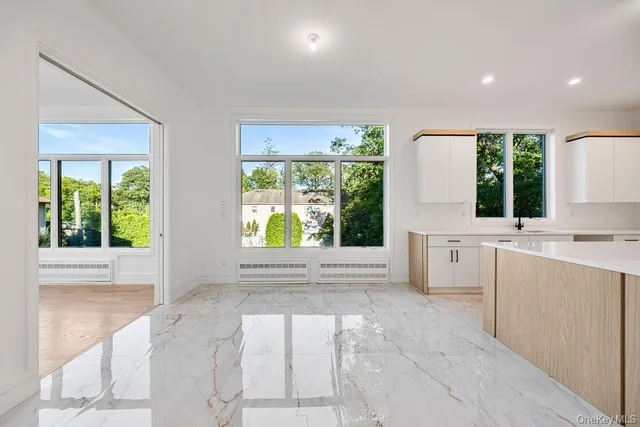 a view of a kitchen with a sink and dishwasher with wooden floor