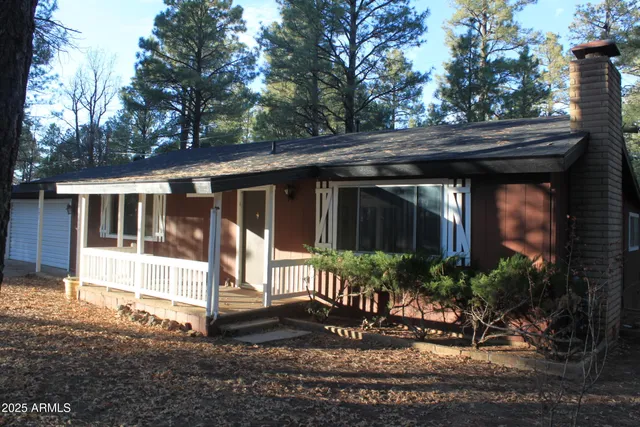 a view of a house with a small yard plants and large tree