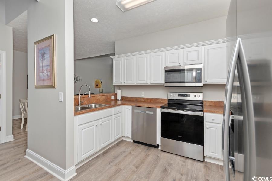 110 Cart Crossing Drive, Unit 102 Conway, SC 29526 - Photo 15 of 39 Kitchen featuring stainless steel appliances, white cabinets, light wood-type flooring, recessed lighting, and a textured ceiling
