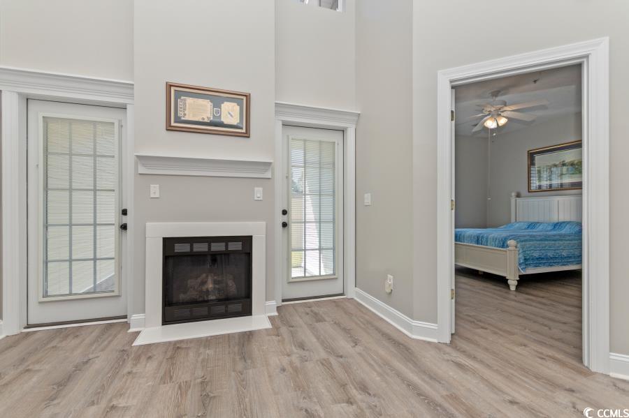 110 Cart Crossing Drive, Unit 102 Conway, SC 29526 - Photo 7 of 39 Living area with light wood finished floors, a fireplace with flush hearth, a ceiling fan, and a towering ceiling