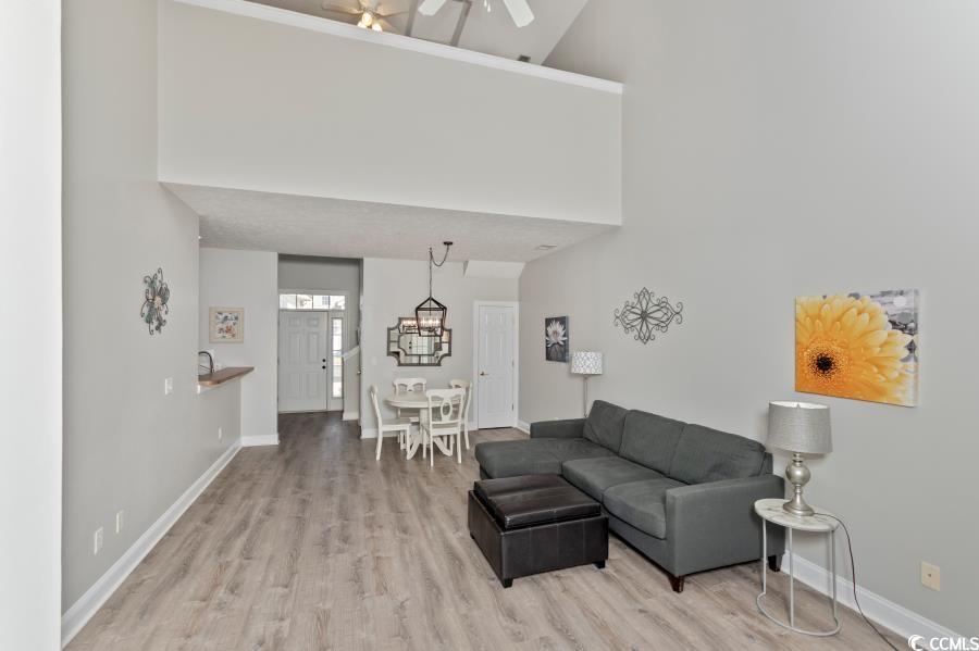 110 Cart Crossing Drive, Unit 102 Conway, SC 29526 - Photo 8 of 39 Living room with a towering ceiling, light wood-style flooring, and a ceiling fan
