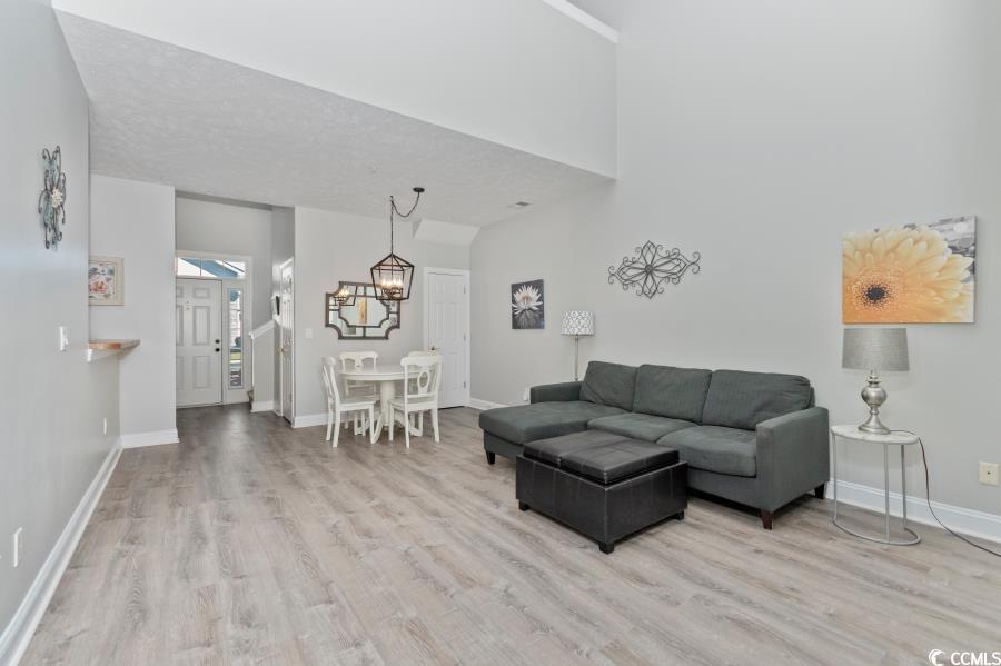 110 Cart Crossing Drive, Unit 102 Conway, SC 29526 - Photo 9 of 39 Living area with light wood-style flooring, a high ceiling, and a chandelier