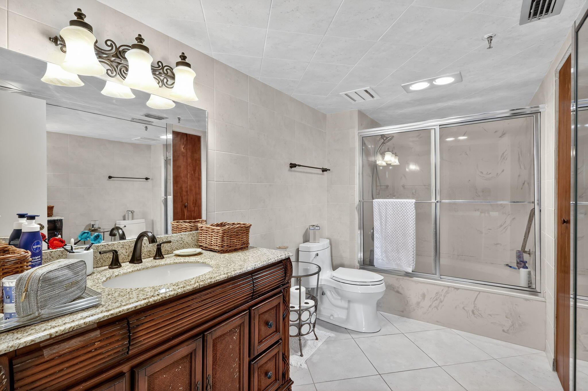 5340 Northwest 2nd Avenue, Unit 421 Boca Raton, FL 33487 - Photo 27 of 54 a bathroom with a granite countertop sink a toilet and a mirror