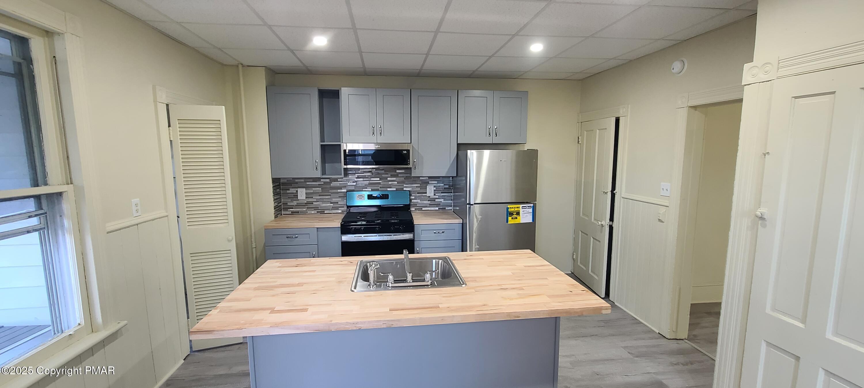 722 Monroe Street Stroudsburg, PA 18360 - Photo 2 of 11 a kitchen with stainless steel appliances kitchen island a refrigerator sink and wooden cabinets