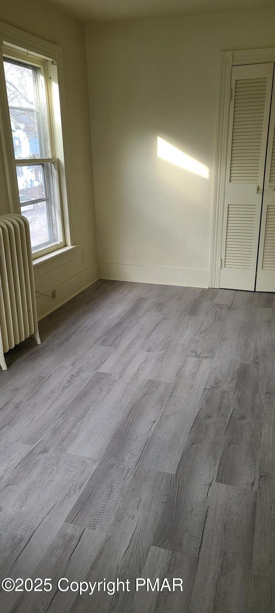 722 Monroe Street Stroudsburg, PA 18360 - Photo 6 of 11 an empty room with wooden floor and windows