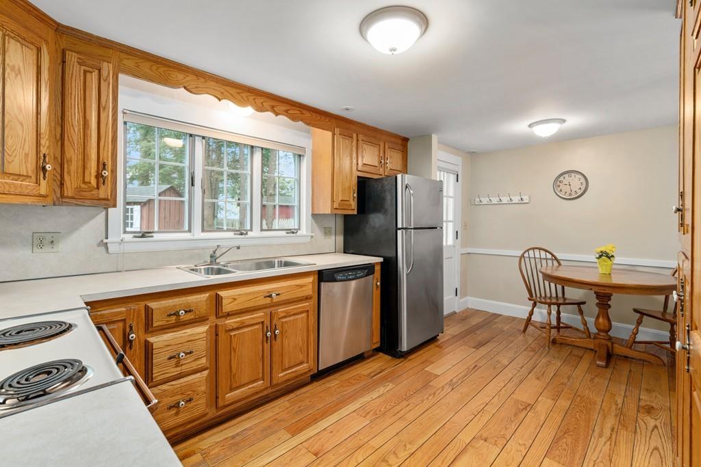 75 Morningside Road Needham, MA 02492 - Photo 9 of 28 a kitchen with stainless steel appliances granite countertop a refrigerator a sink dishwasher a dining table and chairs with wooden floor