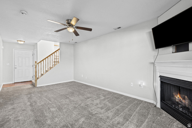 652 West 800 North, Unit 45 Clinton, UT 84015 - Photo 7 of 17 Living area featuring gray carpeting, a fireplace with a white mantel, and a ceiling fan with integrated lighting