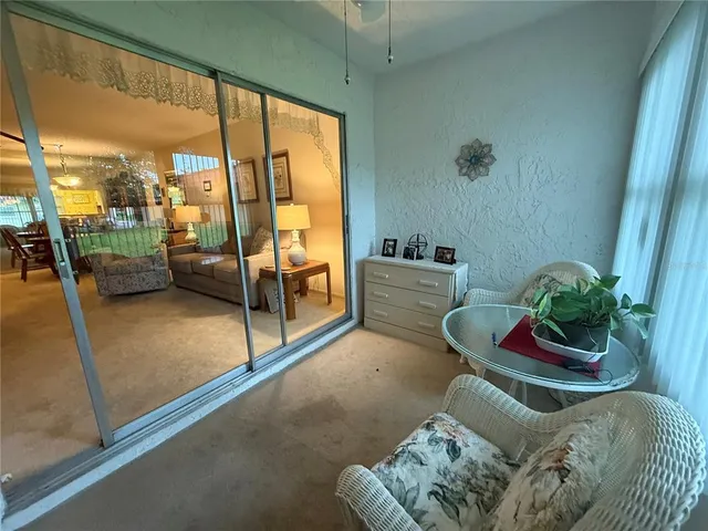 a living room with furniture and a floor to ceiling window