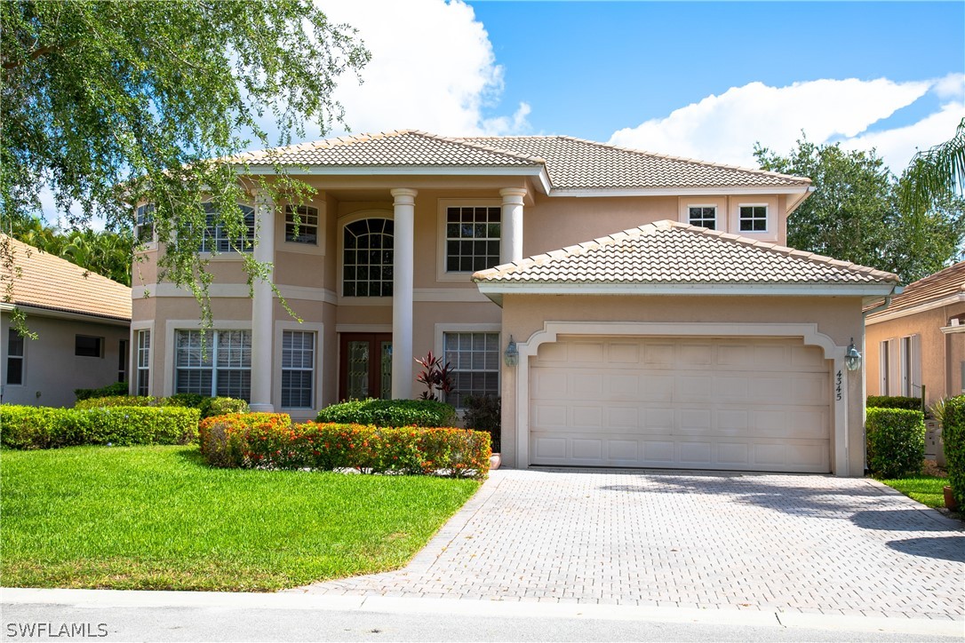 4345 Mistlethrush Lane Naples, FL 34119 - Photo 1 of 29 a front view of a house with a yard and garage