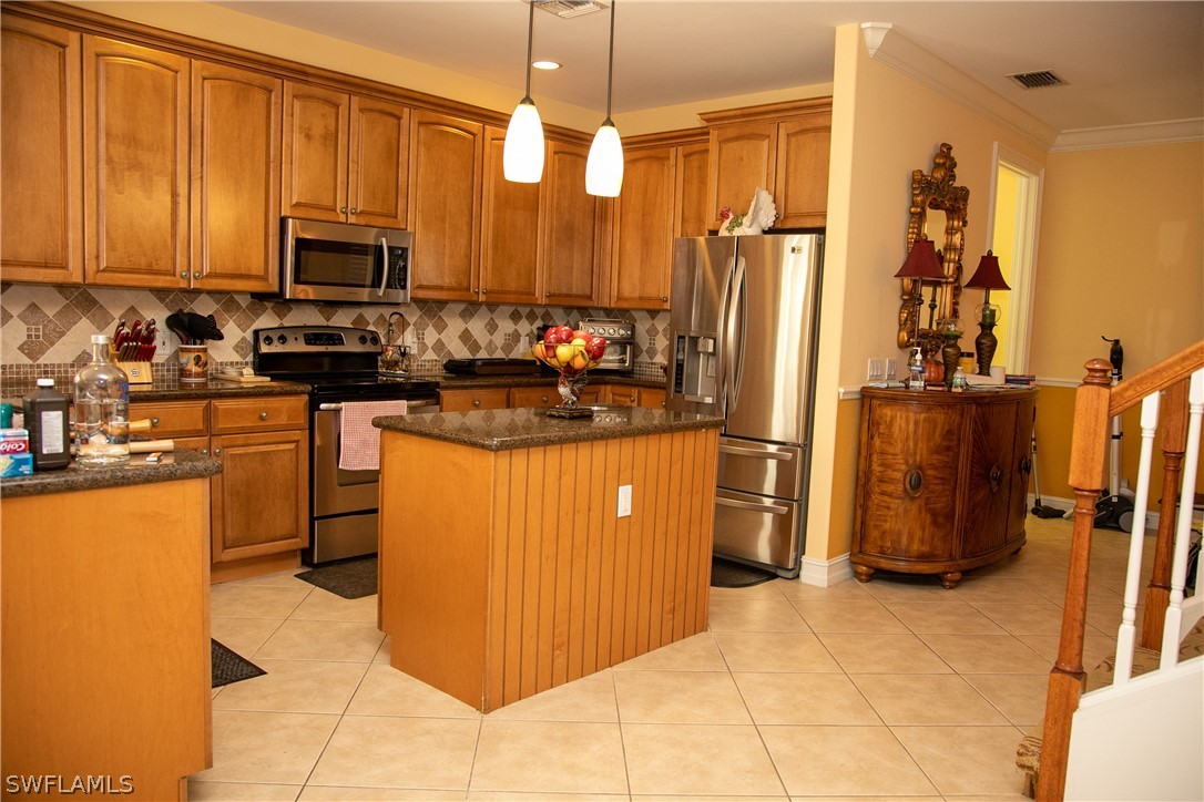 4345 Mistlethrush Lane Naples, FL 34119 - Photo 14 of 29 a kitchen with stainless steel appliances granite countertop a refrigerator a stove top oven a sink and dishwasher