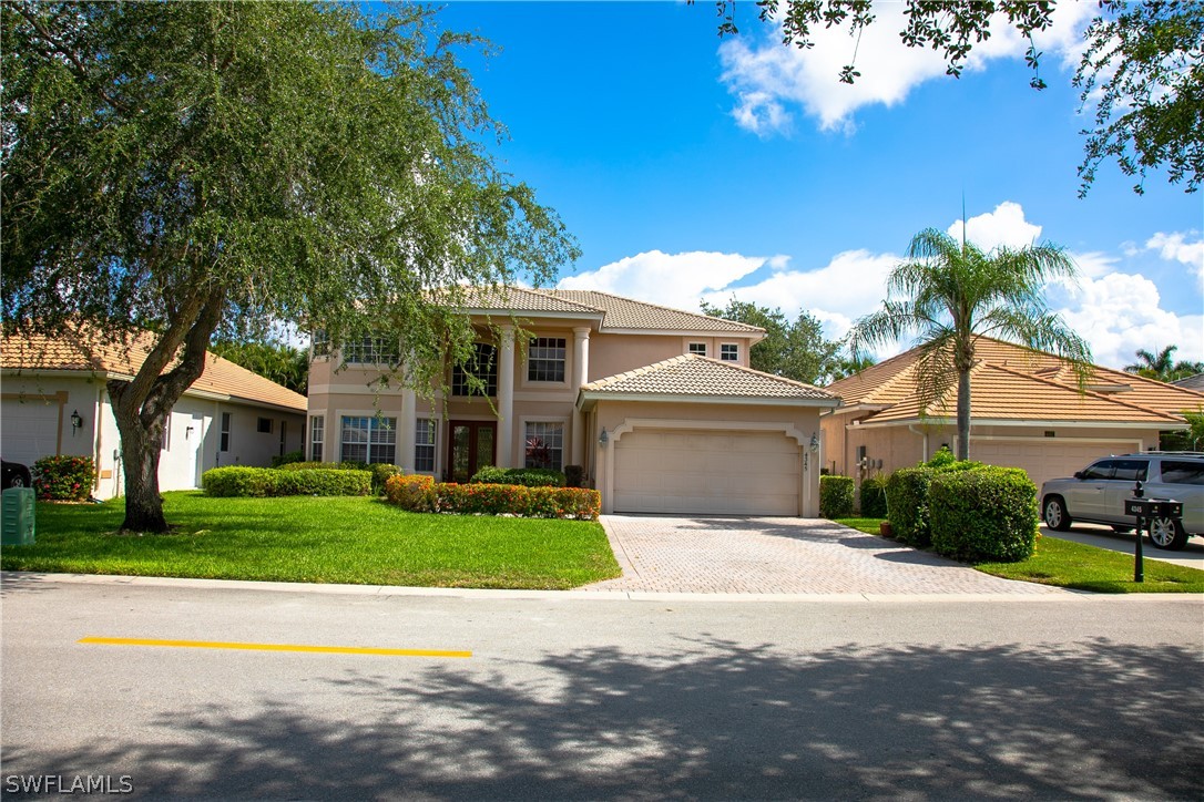 4345 Mistlethrush Lane Naples, FL 34119 - Photo 2 of 29 a front view of a house with a yard and garage