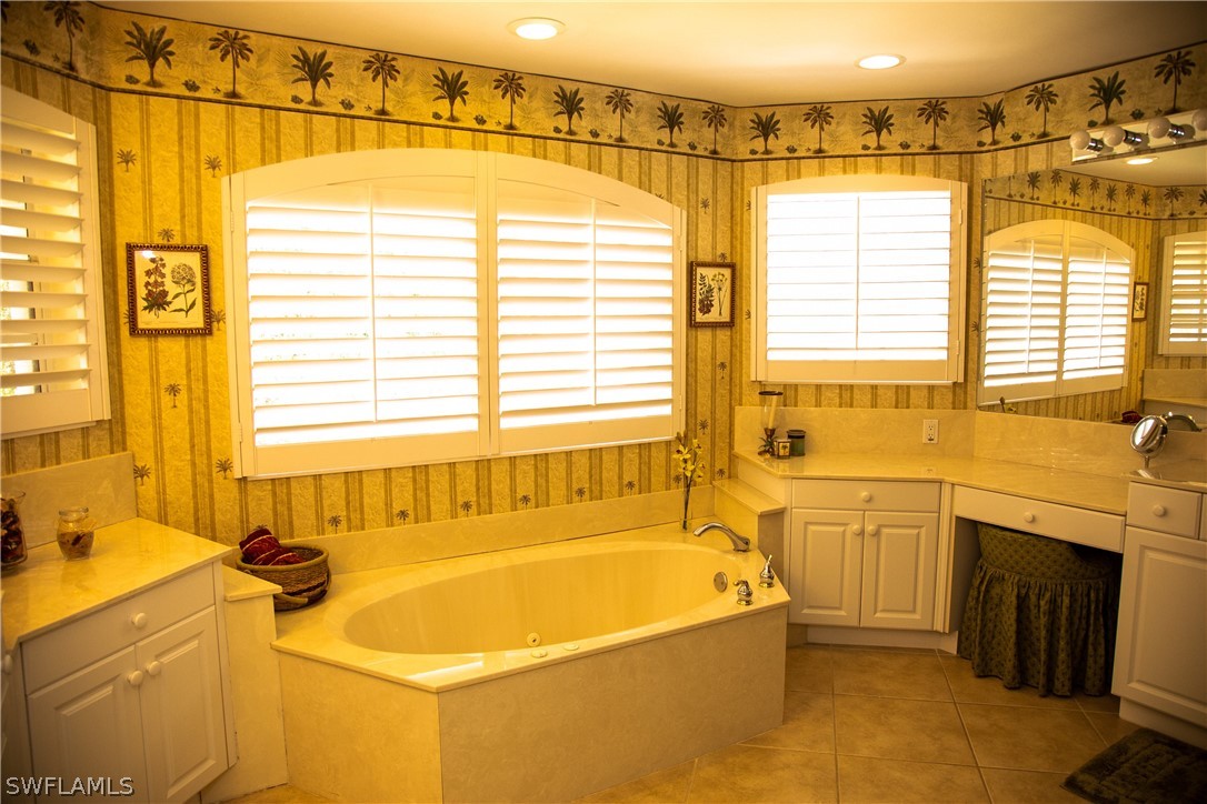 4345 Mistlethrush Lane Naples, FL 34119 - Photo 23 of 29 a bathroom with a granite countertop sink and a bathtub