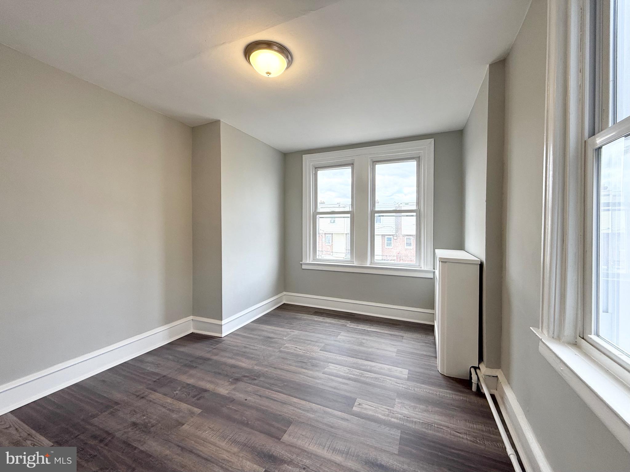 5842 North Hope Street Philadelphia, PA 19120 - Photo 22 of 45 an empty room with wooden floor and windows