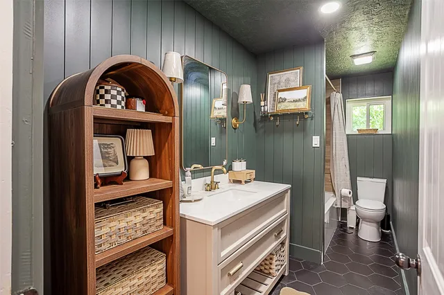 a bathroom with a sink a toilet and a mirror