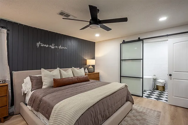 a bedroom with a large bed and a chandelier