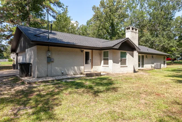 a front view of a house with a yard and trees