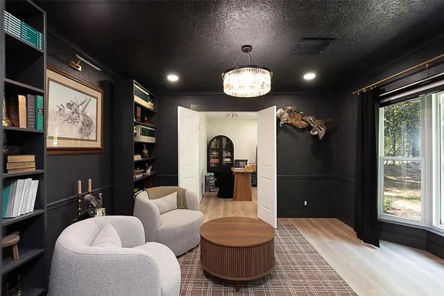 a living room with furniture a bookshelf and a large window