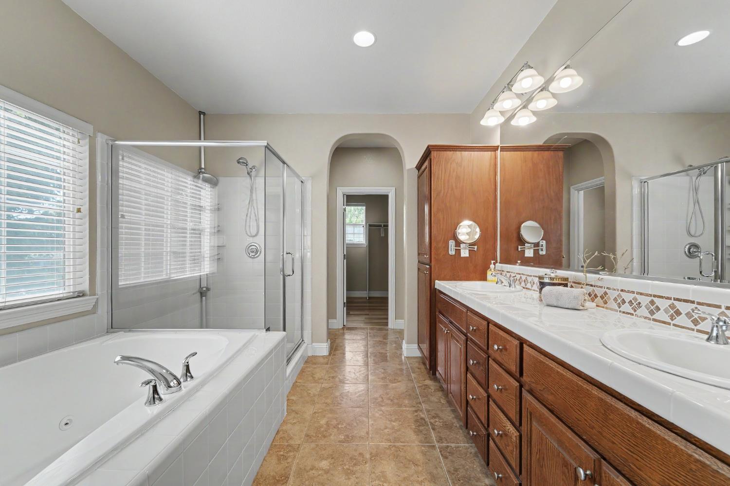 1223 East Springer Drive Turlock, CA 95382 - Photo 27 of 48 a spacious bathroom with a granite countertop sink a large mirror and a bathtub