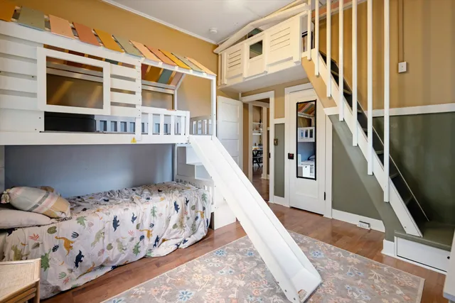 a view of a bedroom with wooden floor and staircase