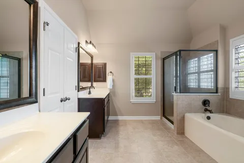 a bathroom with a tub sink and mirror