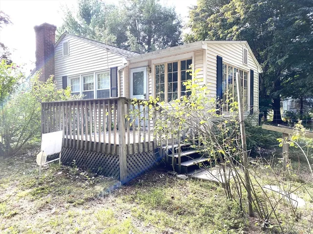 a view of a house with a wooden fence and a yard