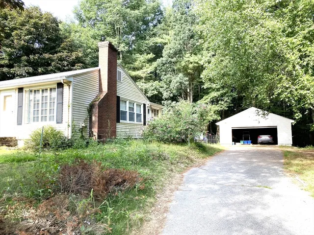 a view of a house with a yard and potted plants