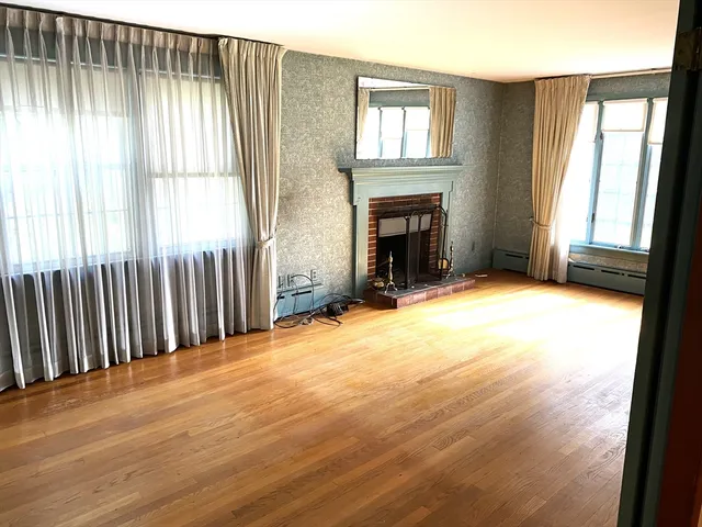 a view of an empty room with a fireplace and a window