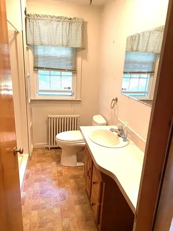 a bathroom with a sink toilet and a mirror