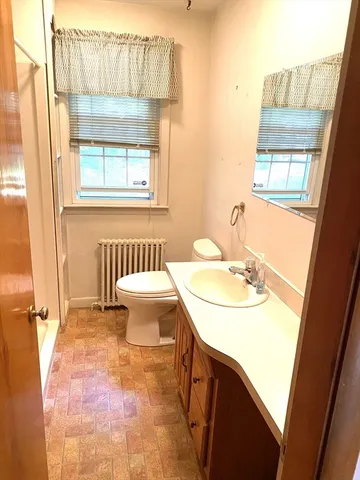 a bathroom with a sink toilet and a mirror