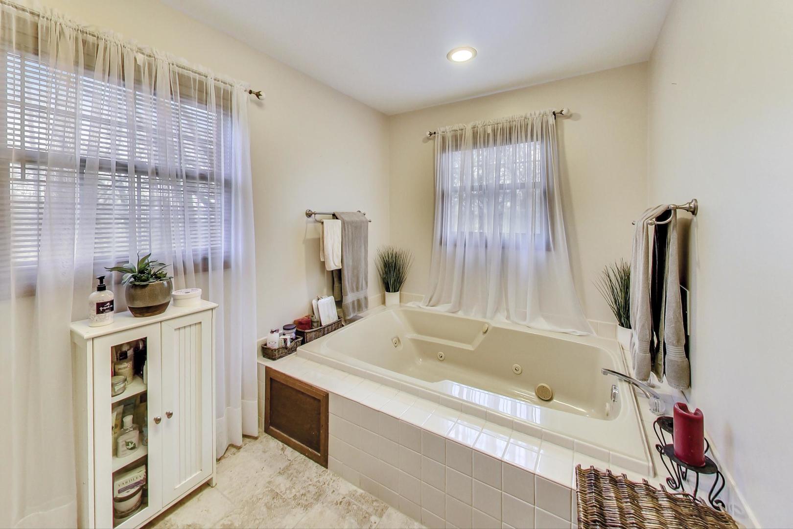 2185 Maplewood Drive Gurnee, IL 60031 - Photo 28 of 65 a bathroom with a tub sink and a mirror
