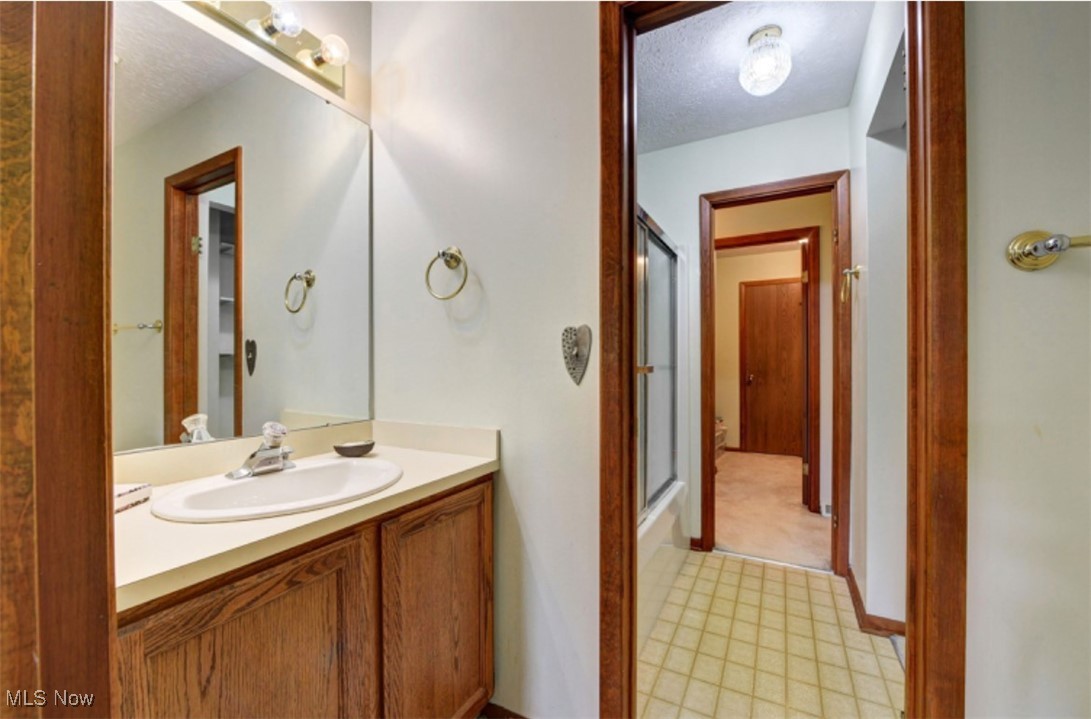 22536 Center Ridge Road, Unit A Rocky River, OH 44116 - Photo 25 of 32 Bathroom with vanity, combined bath / shower with glass door, and tile patterned floors