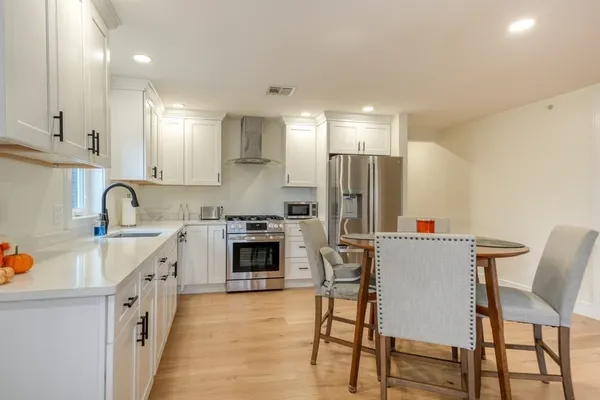 a kitchen with white cabinets and stainless steel appliances