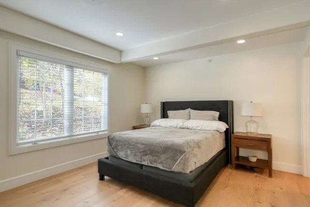 a bedroom with a bed table and window