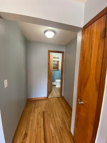 a view of a room with wooden floor and a bathroom