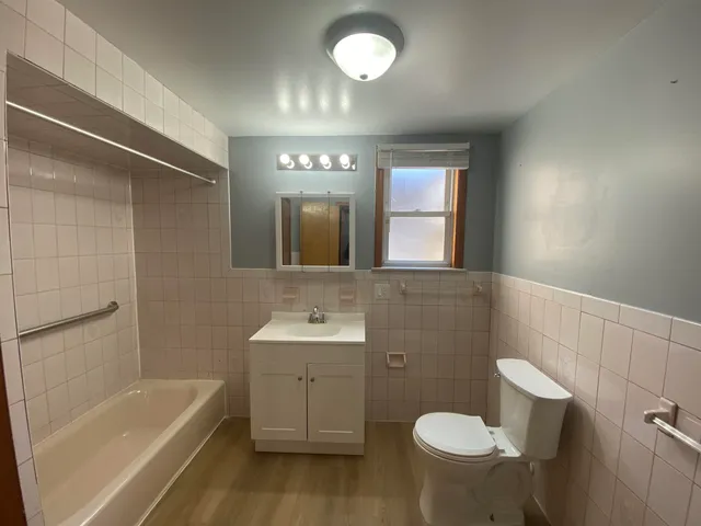 a bathroom with a sink toilet a mirror and bathtub