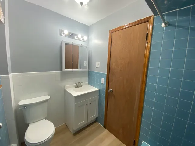a bathroom with a toilet a sink a shower and mirror