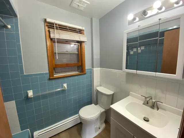 a bathroom with a toilet sink and mirror